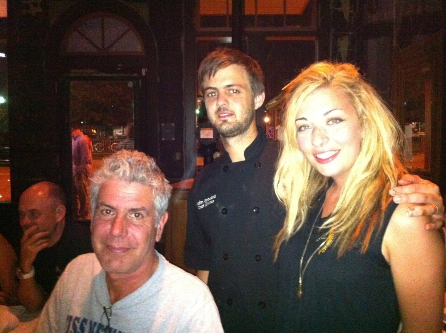 A man and woman posing with Anthony Bourdain